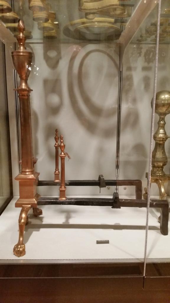 brass andirons in a case at met museum by mriver