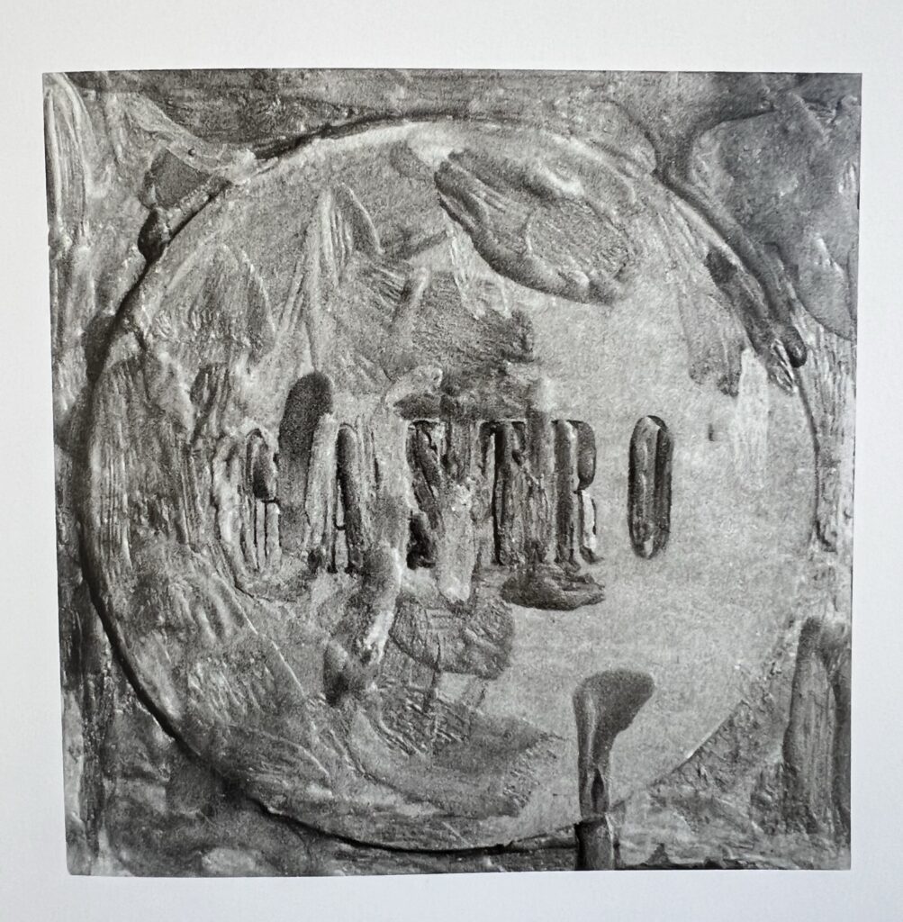 black and white photo of jasper johns' lost 1964 painting titled gastro after the name of the bar owned by miyagaki shoichiro and his wife kiyo, which is printed on the round coaster affixed to the 5-inch square canvas by brushy blobs and drips of encaustic. one of four missing or lost paintings by jasper johns, it disappeared when gastro closed in 1988.