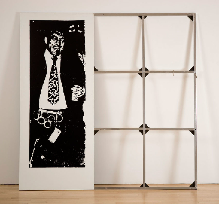 clip-on man is a 1989 work by cady noland depicting a cropped photo of a wild drunk middle aged white guy in a dark suit with empty six pack rings clipped to his belt, a beer in his hand, and one left dangling in front of his crotch. the image is screenprinted in black on an aluminum panel, while a grid like a flimsy set of strainer bars sticks out on the right side, roughly forming a square. the work sits on a wood floor and leans against a white wall. the pic is via gagosian but the work is currently on loan from the artist [shhhh] to glenstone. the photo is by a guy named charles gatewood; he took it at mardi gras in the early 70s