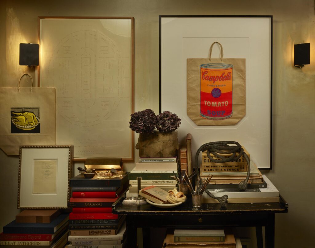 a snapshot of a chic cluttered interior of paris art dealer robert william burke's apartment. art books stacked on antique tables and chairs are pedestals for little artworks. shopping bags by lichtenstein and warhol are framed on the wall between or below two black charlotte perriand sconces, and one of burke's twombly sketches sits on top of a stack of books in a gilt frame. via artcurial, though i think it actually came from barnaby's or someplace, because artcurial started deleting its burke and/or twombly-related content.