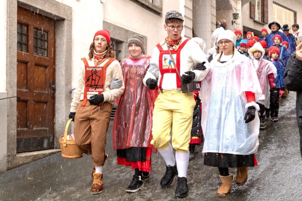 four pink swiss teenagers, arms linked, in traditional engadin dress lead a procession of smaller children down a city street in st moritz for chalandamarz 2024, the march 1st festival to ring forth the spring with cowbells and chase away winter spirits with whips. the girls wear plastic bag ponchos over their elaborately embroidered dresses. the boys wear ersatz knickers held up by red flannel braces. the boy on the left, with the cream cable knit sweater and shoulder-length hair, looks straight at the camera. the handpainted panel of a portrait of a cow or something that normally goes on his chest, framed by the braces, has been replaced by photoshop with the red exhibition catalogue of jean-michel basquiat engadin, and the skier. it is possible, even probable, that chalandamarz motifs should be forward-looking, like a cow on green grass, and not winter-oriented, like a skier. but we make conceptual art gestures with the world we're given, and the exhibition at hauser & wirth feels like one part of a larger swiss interest in themselves, and themselves as connoisseurs and patrons of and a culture apart from, basquiat's. so i hope the gemeinde st moritz will understand a slight liberty taken with this holiday reference, while appreciating, if not exaggerating, the attention and appreciation of engadin culture itself.