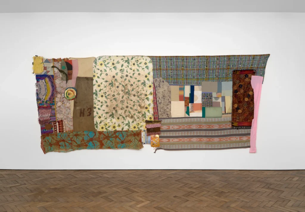 the largest susan cianciolo textile work at stuart shave in london in 2024-25 is twice as wide as it is tall, and basically comprised of two square compositions stitched together. all over are patchworked fabrics of various colors, designs, sources, textures, most with a vertical orientation, except at the bottom, where horizonal pieces give the feel of a base. the work is titled run home and old sicilian table cover combined, possibly a reference to cianciolo's run collection, so maybe one side was a product all its own, the table cover spurred the rest of the composition into shape. just speculating tho, who knows