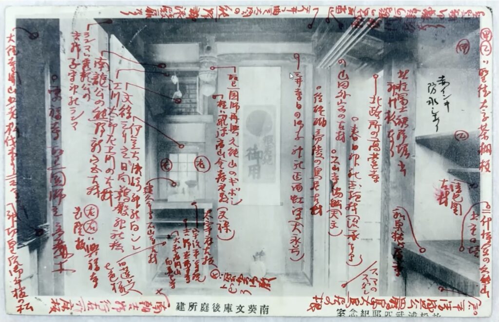 an early 1900s photo postcard of a small japanese room showing an offering shelf, a small window, an alcove with a scroll painting of the rising sun, and on the right edge, the corner of a bookshelf, all annotated in red ink by the grandson of the room's creator, matsuura takeshiro, to identify the sources and significance of each piece of wood. via matsuura kinen-kan on youtube