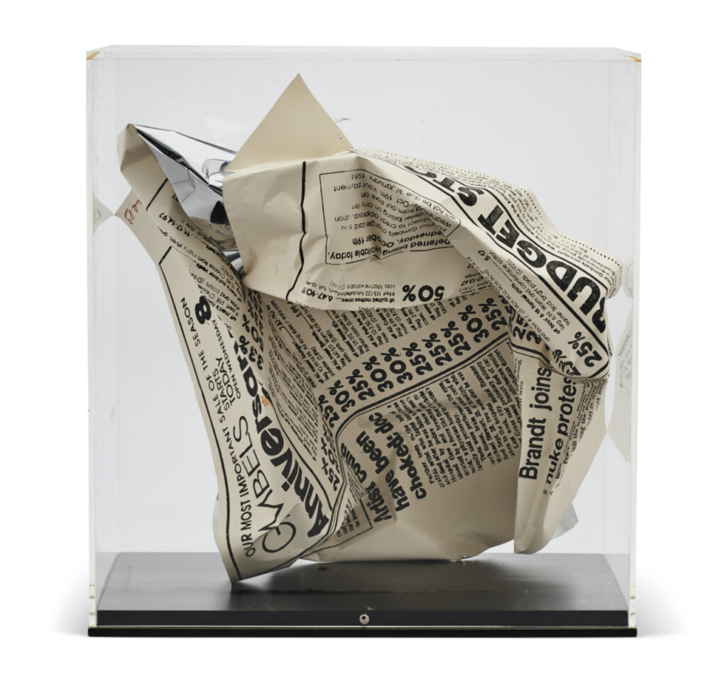 a crumpled sheet of newspaper with an ad for gimbe's department store in a clear plexi vitrine turns out to be a screenprint on metal sculpture by andy warhol from 1983. image prob via christie's