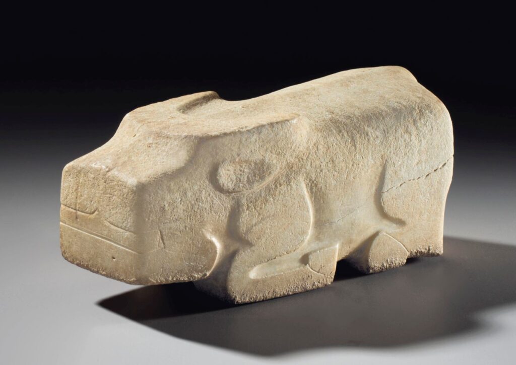 a figure of a kneeling water buffalo carved from a brick-like block of marble, with streamlined and low-relief detailing, made in the shang dynasty, like 1200 bce, and sold at christie's in 2013