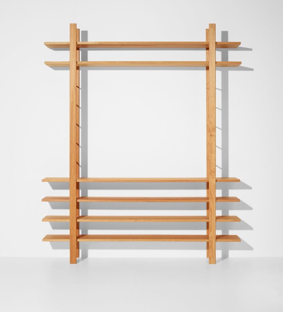 a very simple wood book shelf designed by joseph beuys consists of two vertical ladder like supports and six wooden planks going through them. a stark lighting situation casts shadows of the structure, which is otherwise photographed head on, which kind of privileges composition over detail of the construction. but then, this photo was taken by an auction house to sell it, so