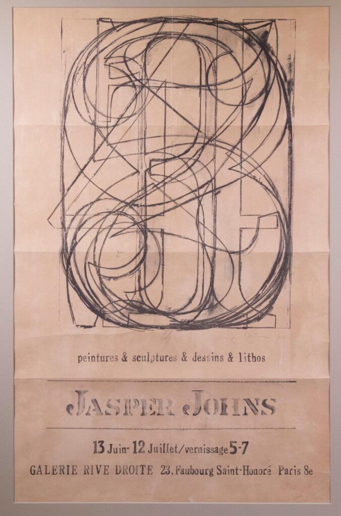 a framed poster of a 1961 jasper johns exhibit in paris is dominated by a reproduction of a johns lithograph, 0-9, with all the numbers drawn over each other. the show was at galerie rive droite in paris.