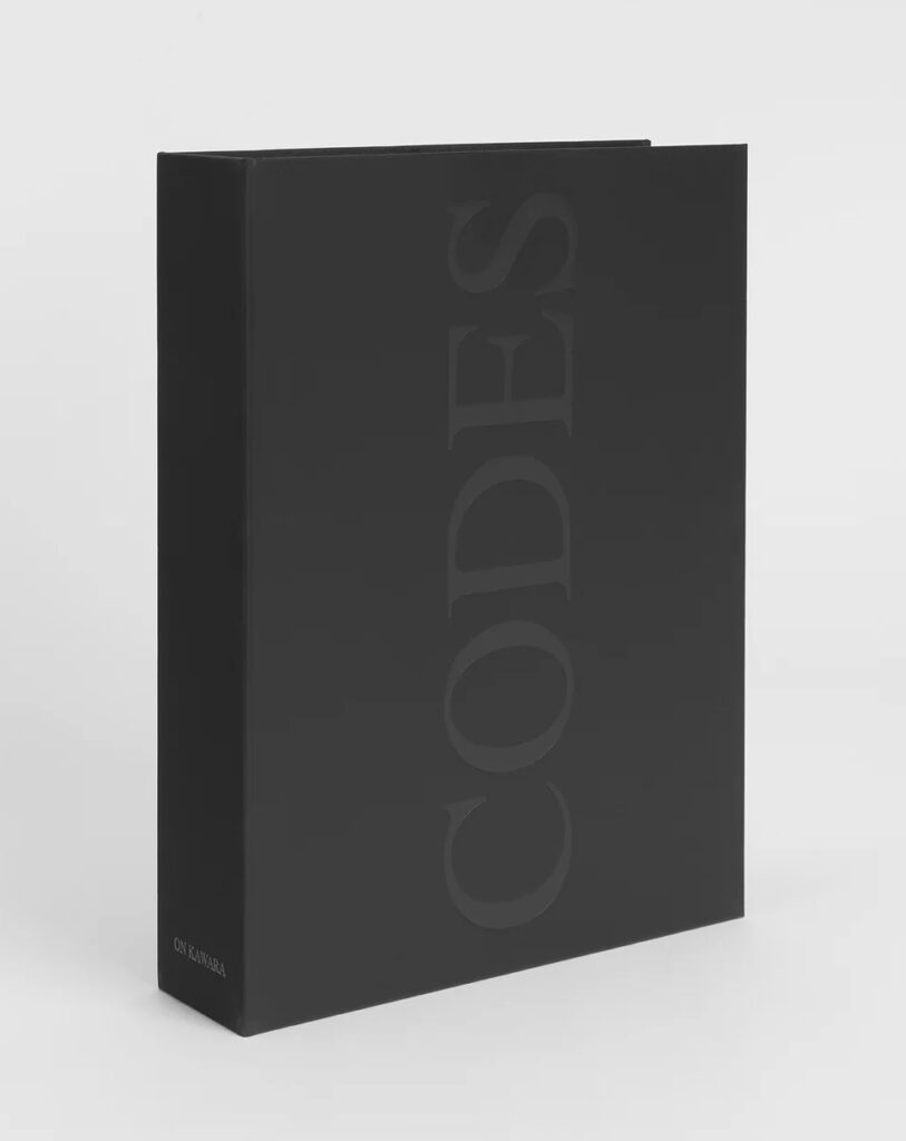 a black cloth covered box with the word codes in all caps debossed large and vertical on the cover, standing in a featureless white space. this is an edition by on kawara published in 1996 by yvon lambert