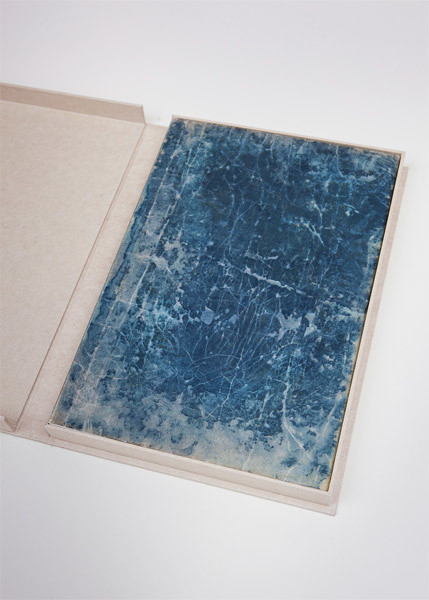 an artist book with an etching of a worn indigo cover of an early japanese book sits in a cream colored clamshell box, the stars by vija celmins and eliot weinberger was published by moma's library council in 2005