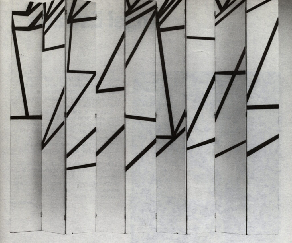 a black and white photo by steven stolman of ellsworth kelly's 1951 nine panel folding screen, each narrow wood panel is white with a thin zig zag of black diagonals across it. the lines are disjointed between panels, because they are based on a photo kelly took of shadows of a hand rail falling irregularly across a flight of concrete stairs in france. la combe ii is one of two (obv) similar works kelly made. I think this one remains in the collection of jack shear, kelly's widower.