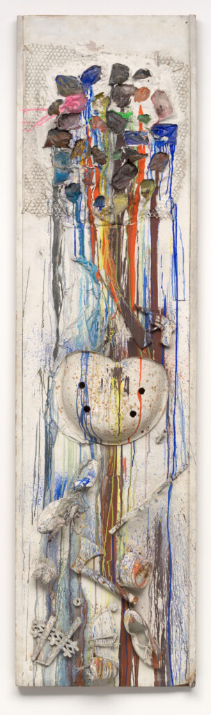 a tall narrow painting by niki de saint phalle, mostly white, with a lattice and plaster clump on the top pocked with open cavities, and various streaks of colored paint run down from them, where plastic bags of paint were shot by the artist. the paint runs over an assemblage of found objects like a tractor seat, a hatchet, i forget what else, all attached to the surface and painted white before getting dripped on. the artist says she shot this one at the american embassy during a performance in june 1961, but other accounts say she pre-shot it. it's at moma now